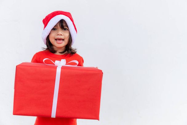 Happy Asian child in Santa red hat holding Christmas presents. Christmas time.on white background. - Foto, immagini