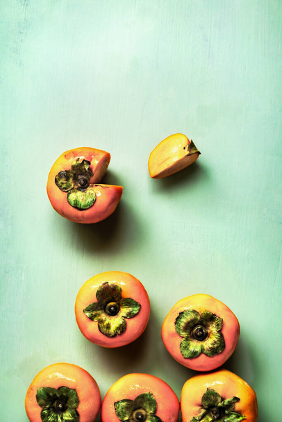 Fresh Persimmons  on green woodboard - Fotoğraf, Görsel