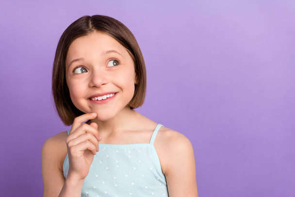 Photo of cute brown hairdo small girl look empty space wear blue top isolated on violet color background - Foto, Bild
