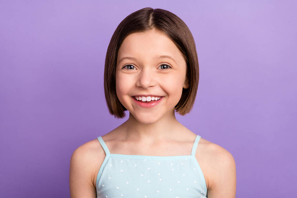 Foto van vrolijk jong gelukkig klein meisje glimlach goed humeur stralen geïsoleerd op paarse kleur achtergrond - Foto, afbeelding