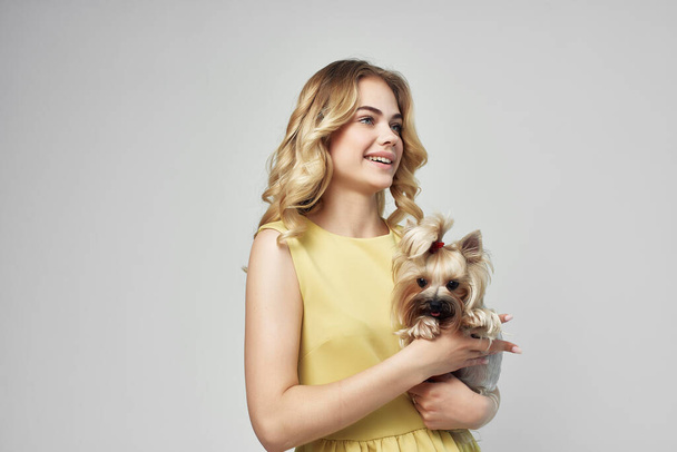 mujer en un vestido amarillo divertido un pequeño perro aislado fondo - Foto, imagen