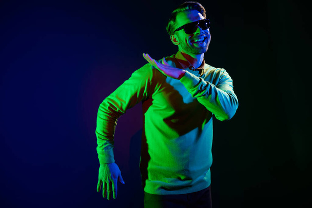 Photo of young funky guy dance wear spectacles sweater isolated on dark blue color background - Fotoğraf, Görsel