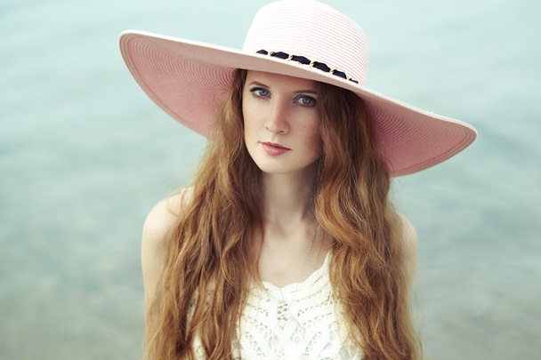Beautiful woman in hat on the sea - Фото, зображення
