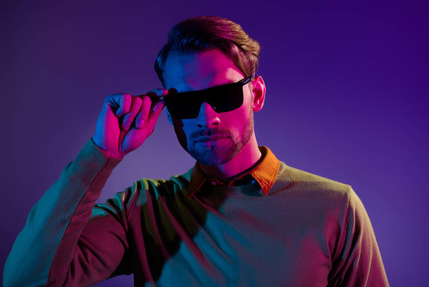 Photo of serious positive cool young man wear sunglass night club life isolated on gradient neon background - Foto, afbeelding