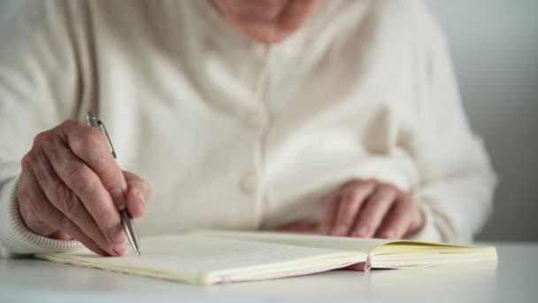 La mujer se quita las gafas de vista haciendo notas en el cuaderno - Metraje, vídeo