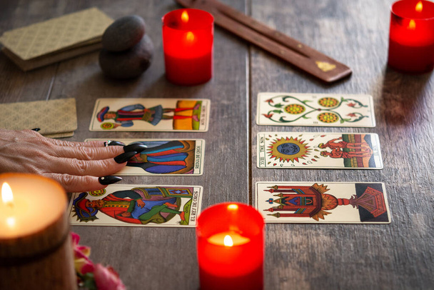 Wahrsagerin liest Zukunft mit Tarotkarten auf rustikalem Tisch - Foto, Bild
