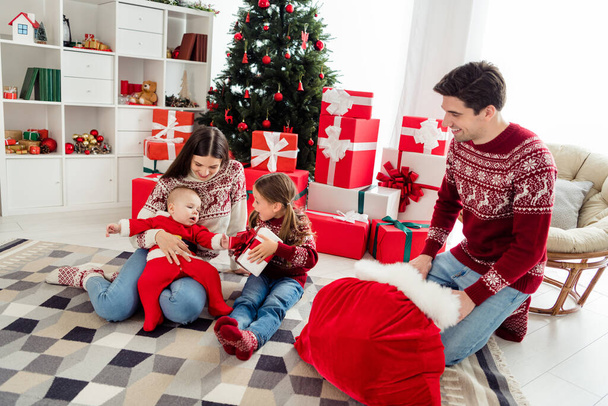 Full lenght photo of young cheerful family happy positive smile santa claus bag present box new year winter indoors - Zdjęcie, obraz