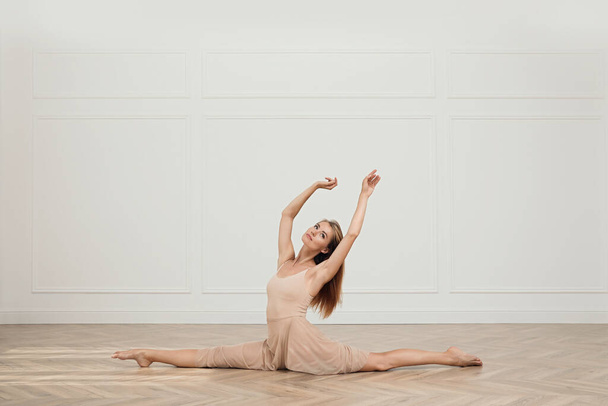 Beautiful professional dancer practicing split in studio - Foto, Bild