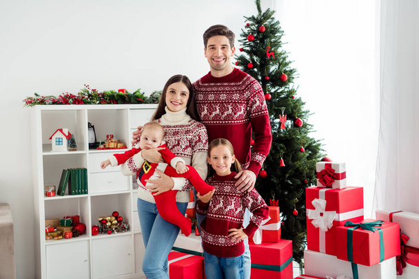 Photo of trustful positive family cuddle infant small baby enjoy atmosphere wear sweater in decorated x-mas home indoors - Foto, afbeelding