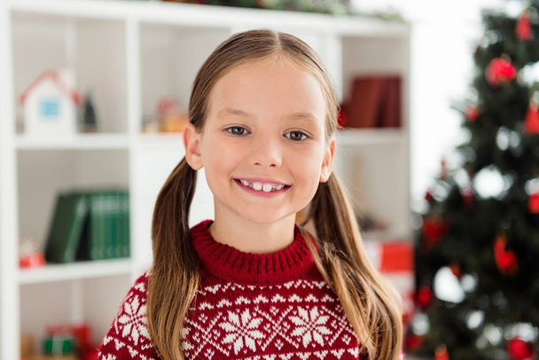 Photo of cheerful young happy small girl holiday mood wear christmas pullover smile in living room apartment - Foto, Bild