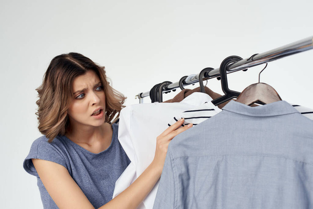 συναισθηματική γυναίκα Shopaholic επιλέγοντας ρούχα ψώνια στο κατάστημα απομονωμένο φόντο - Φωτογραφία, εικόνα