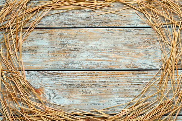 Frame of dried hay on light wooden background, flat lay. Space for text - Foto, afbeelding