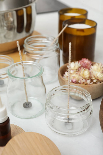 Glass jars with wicks on white kitchen table. Making homemade candles - Valokuva, kuva