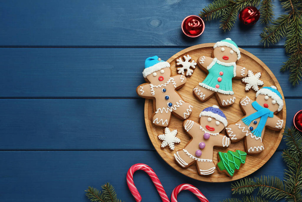 Плоская композиция с вкусным рождественским печеньем на голубом деревянном столе, место для текста - Фото, изображение