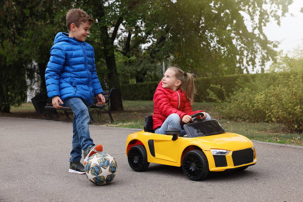 Cute little children with toy car and soccer ball having fun outdoors - Foto, Bild