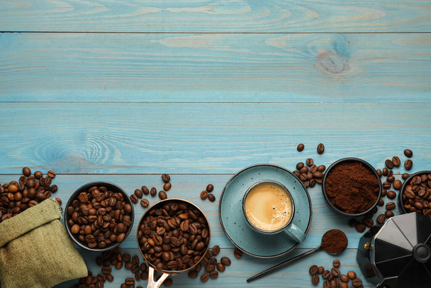 Coffee maker, beans, powder and cup of drink on light blue wooden table, flat lay. Space for text - Fotó, kép