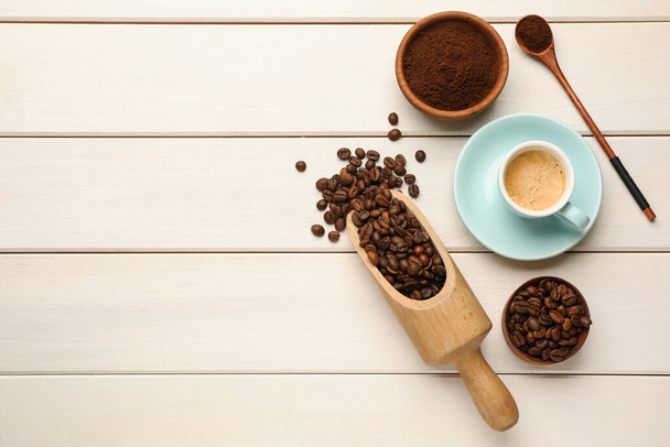 Coffee beans, powder and cup of drink on white wooden table, flat lay. Space for text - Фото, зображення
