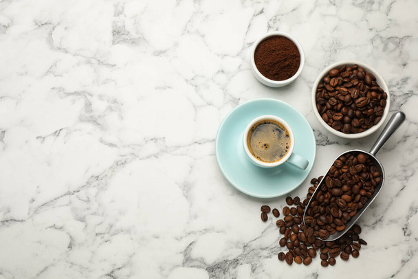 Kaffeebohnen, Pulver und Tasse Getränk auf weißem Marmortisch, flach gelegt. Raum für Text - Foto, Bild