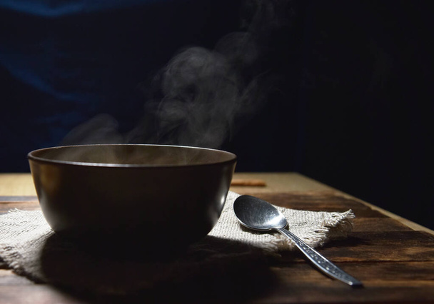 Tökleves püré egy barna tányéron egy fa asztalon - Fotó, kép