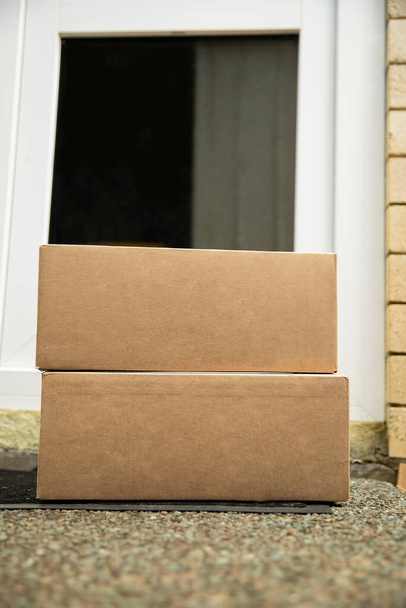 kartonowe pudełka dostarczone do drzwi widelca i pozostawione na zewnątrz do odbioru bezdotykowego, dostawa na zakupy online, dostawa bezdotykowa i odbiór ze względu na COVID-19 - Zdjęcie, obraz