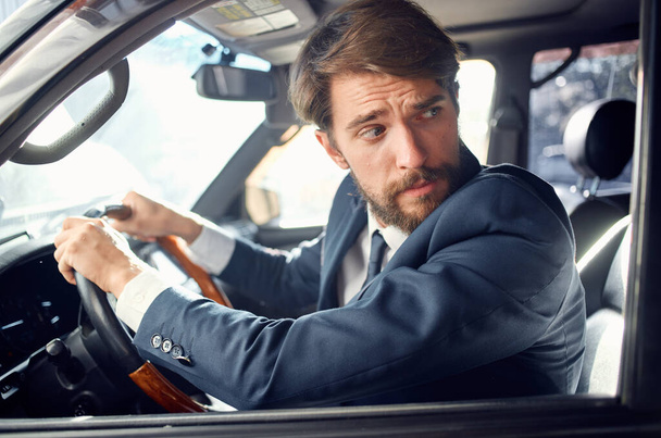 hombre barbudo en un traje en un coche un viaje a trabajar rico - Foto, Imagen