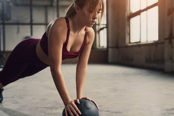 Sporty woman doing plank with medicine ball - Fotografie, Obrázek