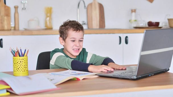 chico está estudiando en una escuela en línea, mostrando la respuesta a la pregunta a través de la comunicación de vídeo - Foto, imagen