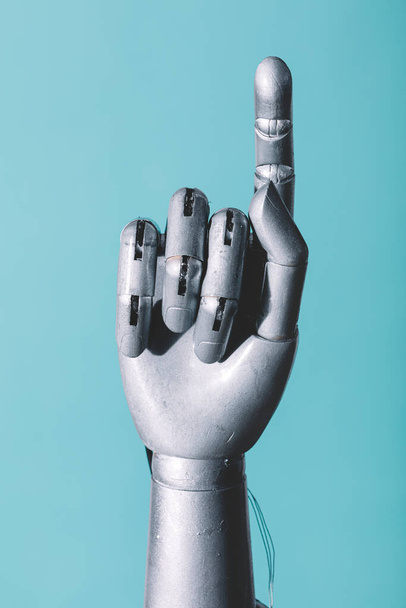 Robotic hand in retro future style pointing finger on blue background - Photo, Image