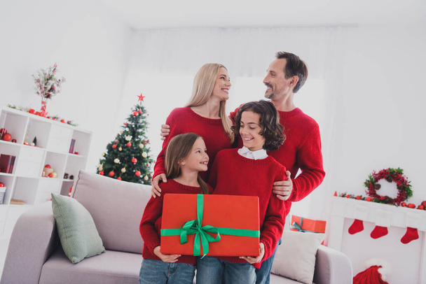 Portrait of careful beautiful handsome cheerful family hugging holding giftbox congrats festal eve at home house indoors - Foto, afbeelding