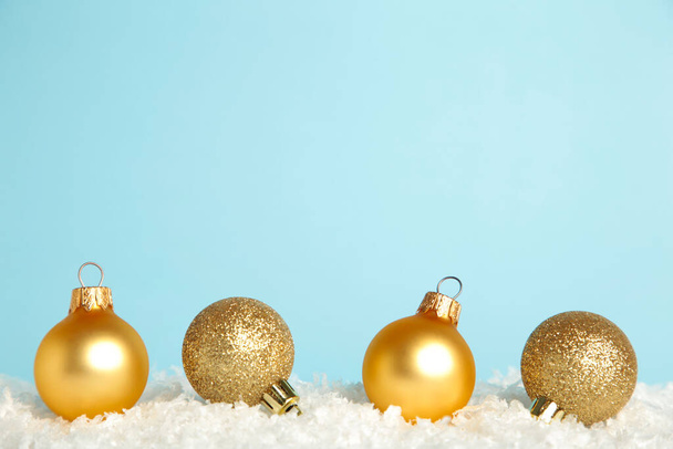 Golden Christmas baubles on snow. Flat lay. New Year 2022. Top view - Foto, afbeelding
