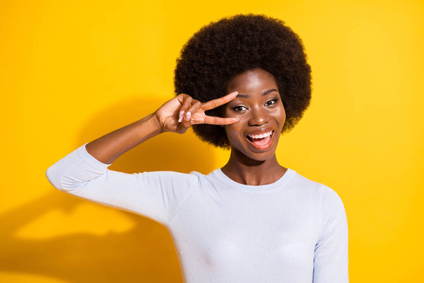 Portrait of optimistic brunette short hair lady show v-sign wear white pullover isolated on vivid yellow color background - Fotografie, Obrázek
