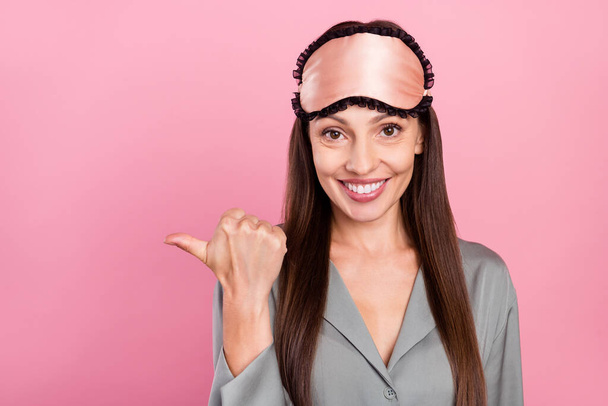 Portrait of attractive trendy cheerful long-haired woman demonstrating copy space solution isolated over pink pastel color background - Foto, immagini