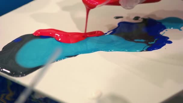 Pouring red paint to the blue on the canvas. - Footage, Video