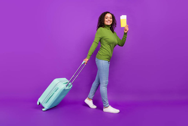 Photo of dreamy excited african lady dressed green turtleneck smiling holding passport baggage isolated violet color background - Photo, Image