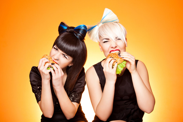twee meisjes met hamburgers - Foto, afbeelding