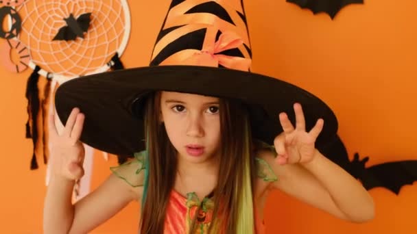 Ein kleines Mädchen im Hexenkostüm hustete während einer Halloween-Party. Das Kind war am Urlaubstag erkrankt. Husten im Ellbogen - Filmmaterial, Video