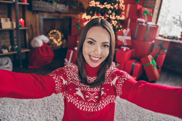 Photo of pretty young lady do selfie wear new year sweater at home alone on christmas eve - 写真・画像