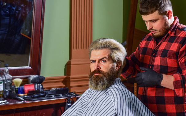 Hipster getting haircut. Barber cosmetics. Hairdresser tools. Barber busy concentrated on process. Styling hair. Near impossible to modify proceedings. Man with dyed hair. Barber hairstyle barbershop - Φωτογραφία, εικόνα