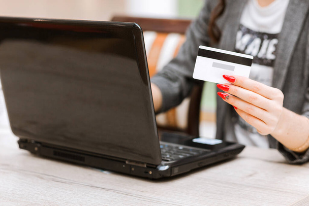 Safe online payment electronic money transfer security. Woman holding in hands credit card,  shopping online purchase internet. Pay with digital technology. Laptop to login to internet bank. Horizontal photo - Foto, immagini
