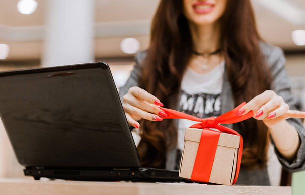 christmas, holidays, technology and shopping concept - smiling woman with credit card on the table, gift box and laptop computer. Horizontal photo - Φωτογραφία, εικόνα