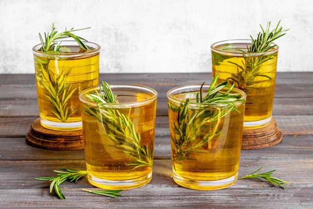 A lot of glasses of lemonade with cold tea and rosemary - Foto, afbeelding