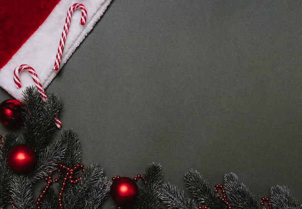 Flatley de Noël. Fond de Noël de branches de sapin, ballons, cannes de caramel, cônes et un chapeau de Noël. Un endroit pour votre texte ou publicité. - Photo, image