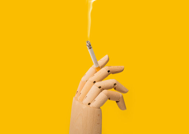 Hand holding a burning cigarette. Smoking addiction and bad habits. Addicted to tobacco cigarettes causing lung cancer. Quit smoking filter cigar because of cancer risk. - Photo, Image