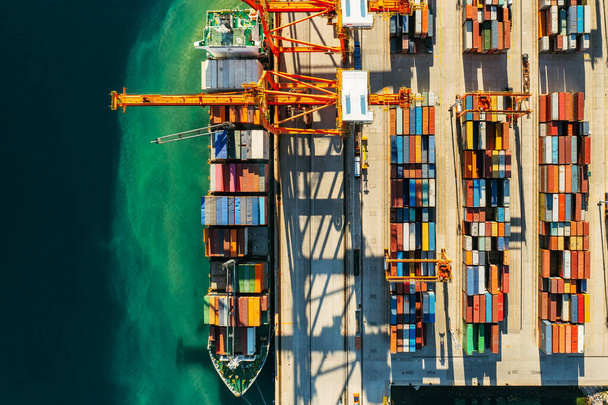 Контейнеры в международных судоходных доках ждут импорта или экспорта и транспортировки. Вид сверху на погрузку контейнеров на судно в порту - Фото, изображение
