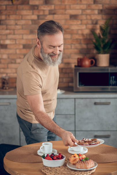 A man getting the breakfast ready and looking involved - Fotoğraf, Görsel