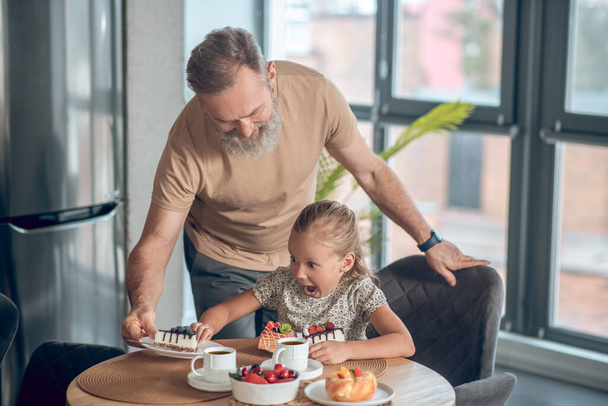 Dad and his daughter having breakfast together at home - Valokuva, kuva