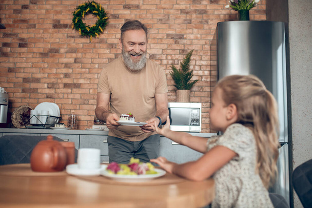 Dad smiling and serving table for his cute daughter - Zdjęcie, obraz
