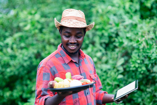 Αφρικανός αγρότης που εκτρέφει λαχανικά. Βιολογικά λαχανικά έτοιμα για σερβίρισμα στην υπηρεσία παράδοσης σαλάτας - Φωτογραφία, εικόνα