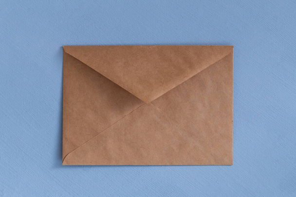 Empty paper craft envelop against light blue background - Zdjęcie, obraz