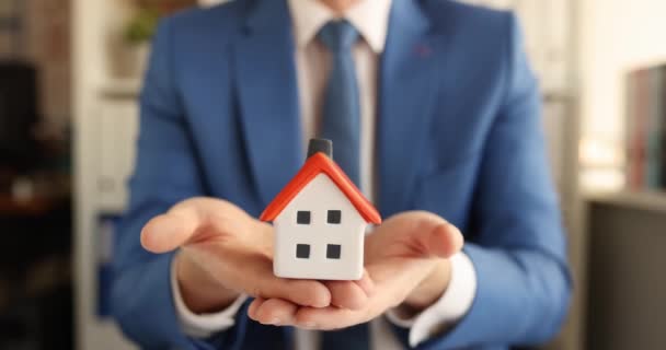 Business man in suit holding small toy house in his hands 4k movie - Footage, Video